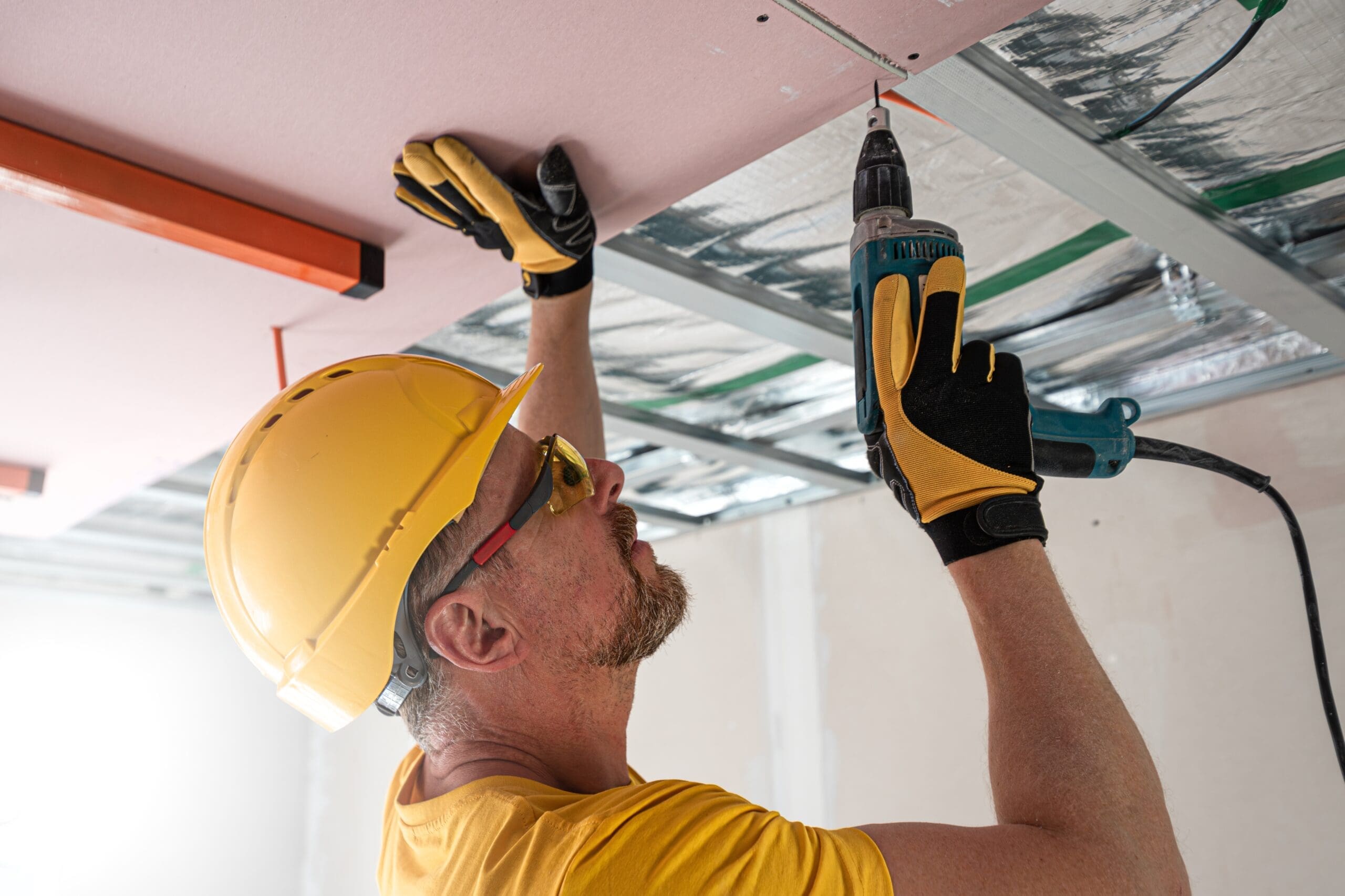 man repairing ceiling drywall